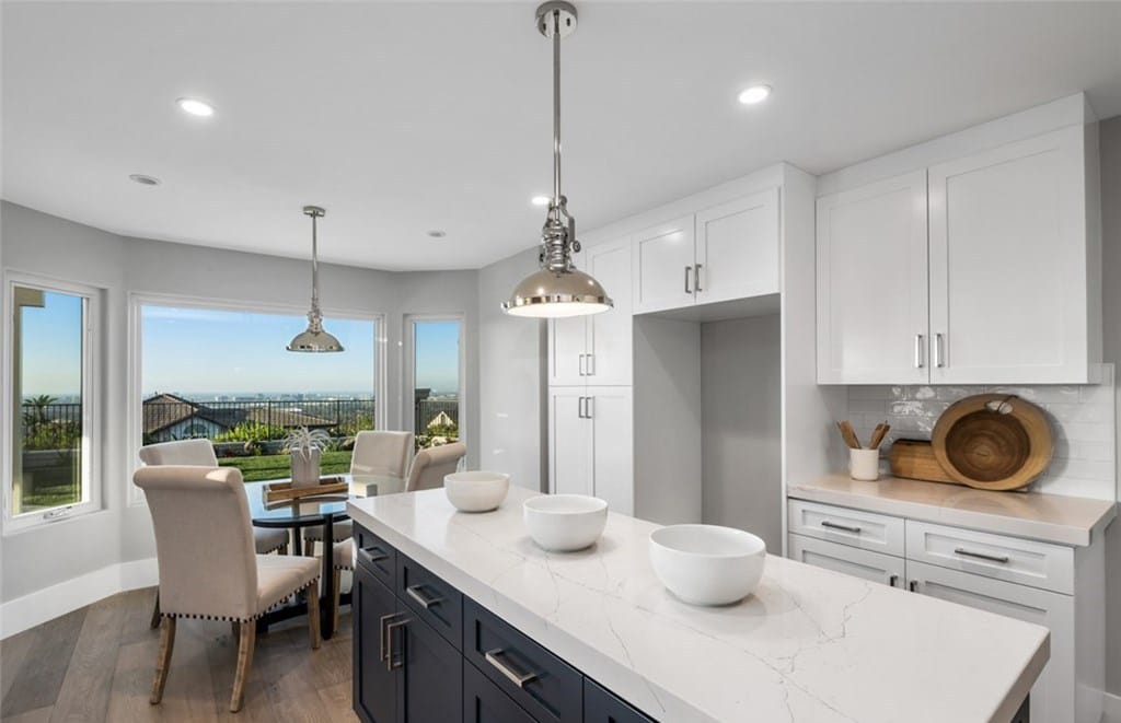 Newly remodeled kitchen with pendant lighting and large window overlooking backyard with city views